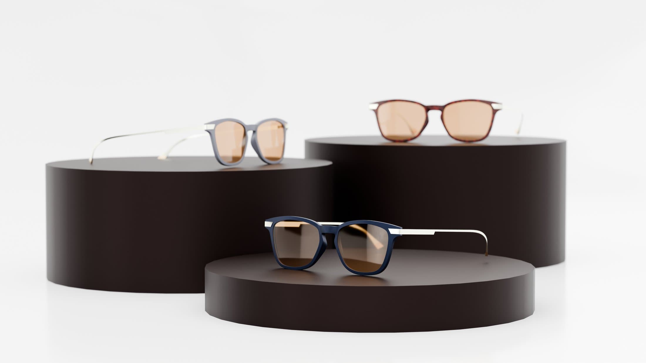 Three pairs of redesigned sunglasses displayed on cylindrical pedestals