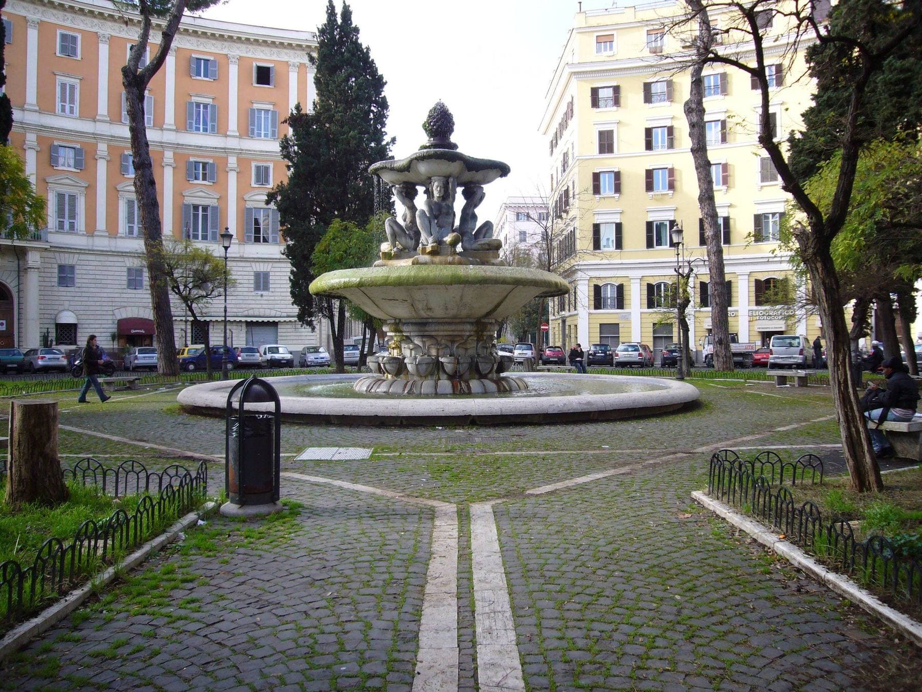 Piazza dei Quiriti in Rome, with benches, a fountain, and a park trash can